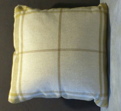Square cushion with a beige and yellow checked pattern on a dark background.