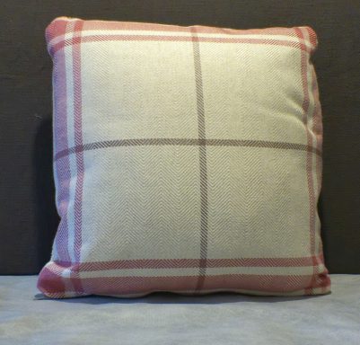 Square cushion with a cream background and pink grid pattern.