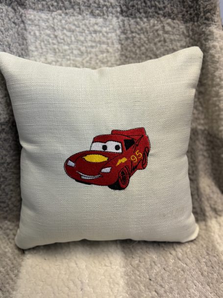 Red cartoon car cushion featuring Lightning McQueen design.