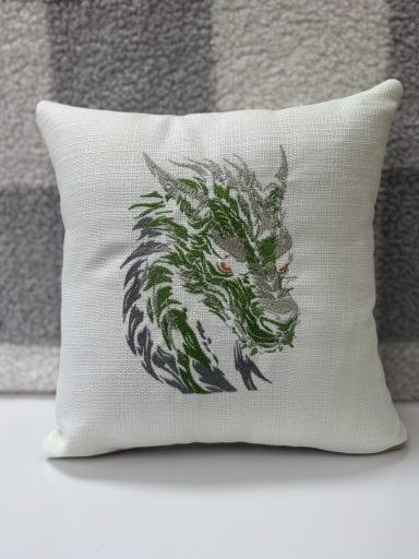 Embroidered dragon design on a decorative cushion with green and silver details.