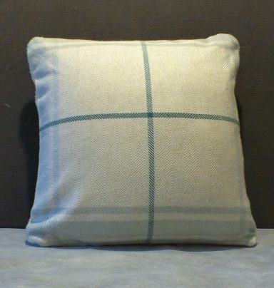 Square cushion in a light fabric with a subtle grid pattern in duck egg blue and grey tones.