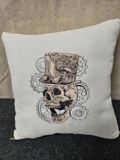 A decorative cushion featuring a skull with a top hat and gear motifs.