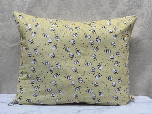 Yellow decorative cushion with a floral pattern and rounded shapes.
