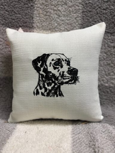 White cushion with a black embroidered profile of a Dalmatian dog.