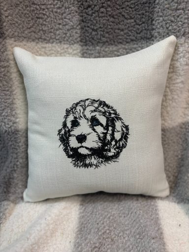 Cushion featuring a black and white illustration of a puppy's face.