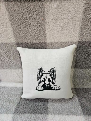 A decorative cushion featuring a black and white illustration of a dog’s face.