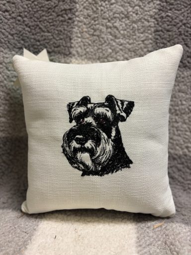 Black and white illustration of a dog's head on a cushion.