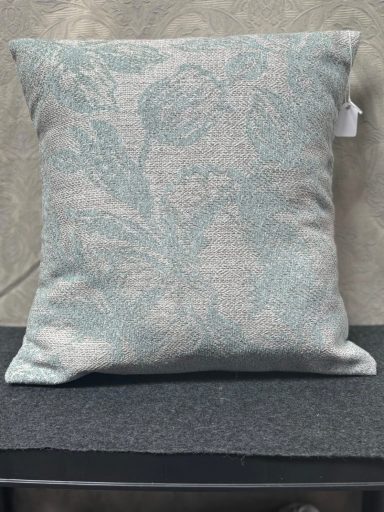 Light blue floral patterned cushion on a grey surface.