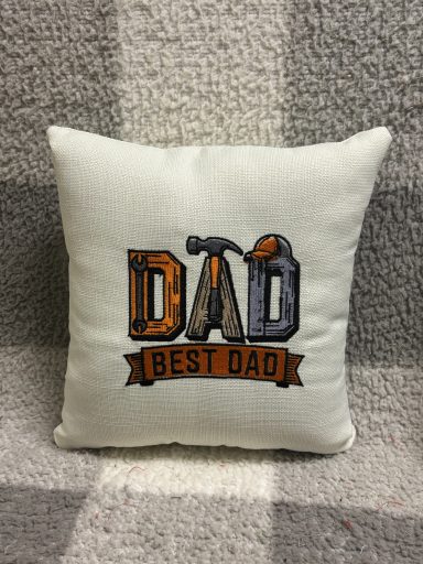Decorative cushion with "Best Dad" text and tools design.