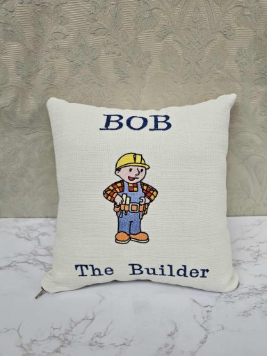 Cushion featuring a cartoon character Bob the Builder with text above and below.