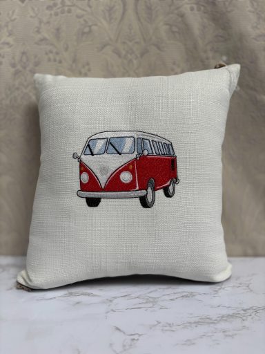 Red and white vintage van embroidered on a cream cushion.