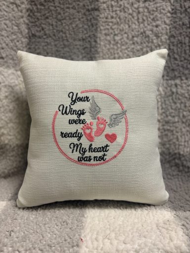 Cushion with embroidered text: "Your wings are ready, My heart you not." Heart and wing graphics.