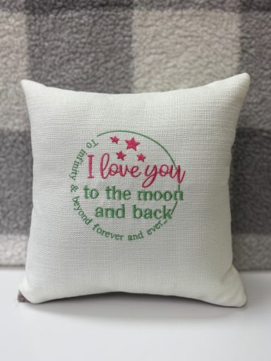 Cushion with the text "I love you to the moon and back" in decorative font.