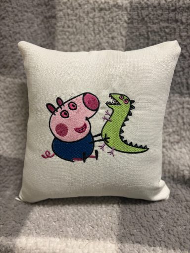Cushion featuring a cartoon pig and a green dinosaur together.