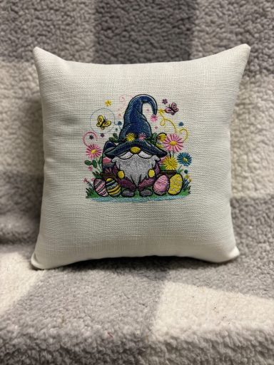 Cushion featuring a gnome surrounded by flowers and colourful eggs.