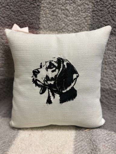 Cream cushion featuring a black silhouette of a dog’s head.