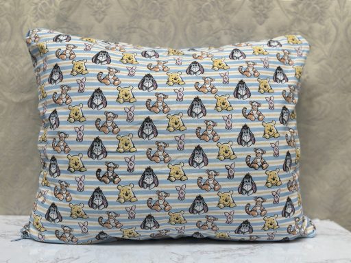 A decorative pillow featuring a playful pattern of animals and stripes.