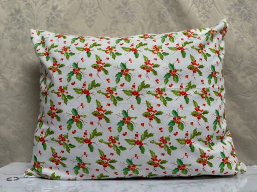 White pillow covered in a vibrant red and green floral pattern.