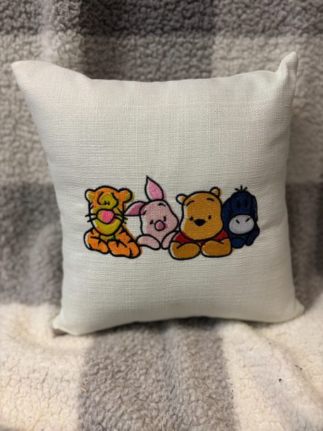 Decorative cushion featuring cartoon characters Tigger, Piglet, Winnie the Pooh, and Eeyore.