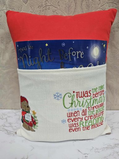 A decorative cushion with festive text, featuring a Christmas theme and bright colours.