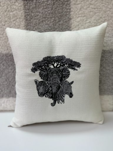Cushion featuring a black animal-themed design on a light fabric background.