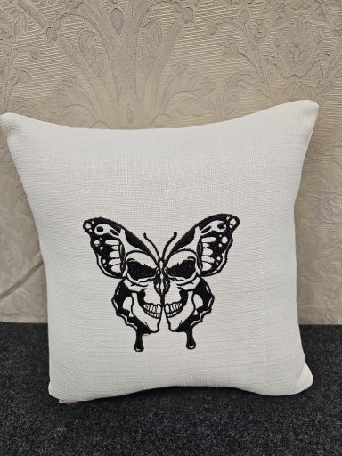 Cushion featuring a black and white butterfly design with a skull motif.