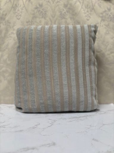 A textured cushion with light blue and beige stripes.