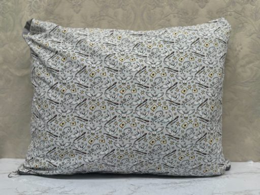 Decorative pillow with a floral pattern in soft grey and yellow tones.
