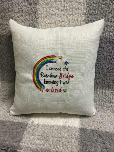 Decorative cushion with "I crossed the Rainbow Bridge knowing I will love" and a rainbow design.