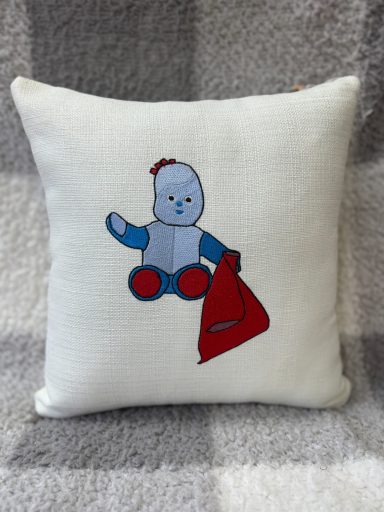 Cushion featuring a cartoon teddy bear holding a red triangular flag.