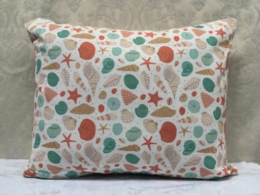Decorative cushion featuring a pattern of seashells and starfish in earthy colours.