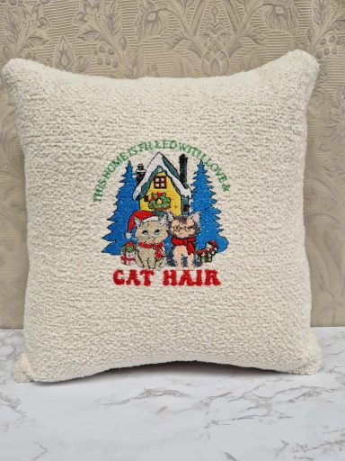 Cream cushion with a whimsical design featuring cats and the text "CAT HAIR."