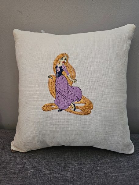 Embroidered cushion featuring a princess character in a purple dress.