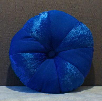 Round, plush cushion in shades of blue, featuring a tufted centre.