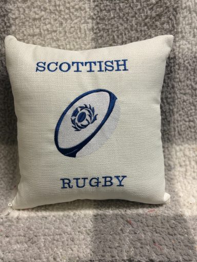 White cushion featuring blue text "SCOTTISH RUGBY" and a rugby ball emblem.