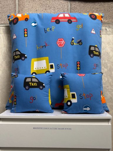 Blue fabric featuring colourful transport-themed patterns with cars, traffic lights, and signs.