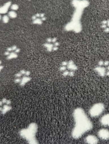Grey fleece blanket patterned with white paw prints and bone shapes.