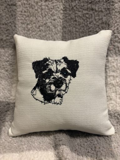 Cushion featuring a black and white illustration of a dog's head.