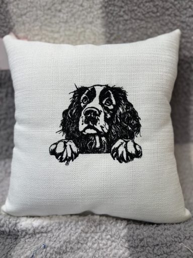 A decorative cushion featuring a black and white illustration of a dog's face.
