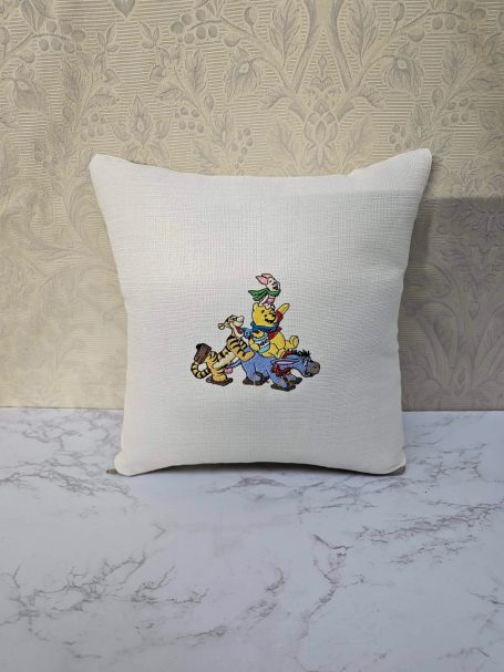 Cushion with an embroidered cartoon character riding a whimsical animal.