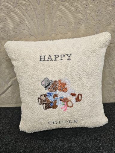 A decorative cushion with the word "HAPPY" and various small brown accessories.