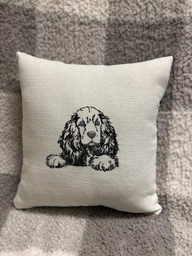 Cushion featuring a detailed illustration of a dog lying down.
