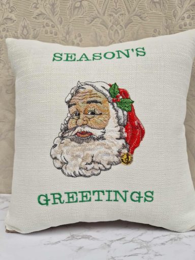 Cushion with an illustration of Santa Claus and the text "Season's Greetings."