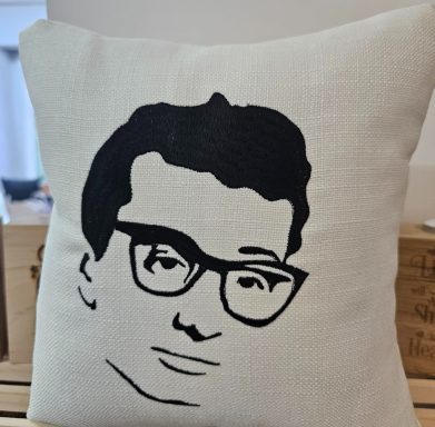 Cushion featuring a stylised black and white portrait of a man wearing glasses.