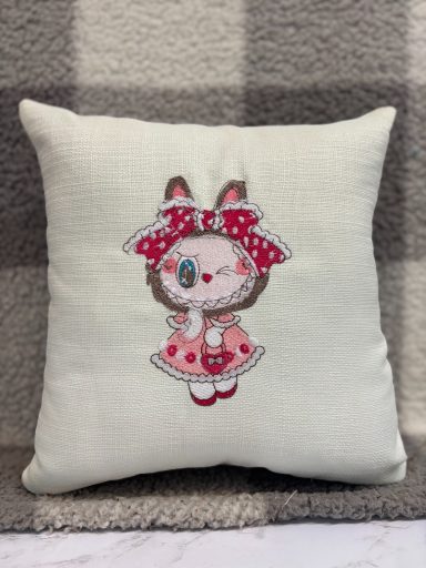 A decorative cushion featuring a cute bunny girl illustration in pink and white.