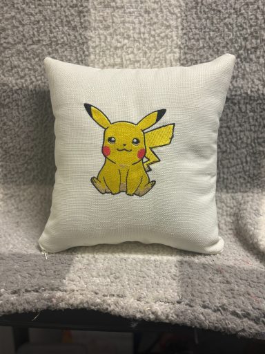 A square cushion featuring a yellow Pikachu sitting with a cheerful expression.