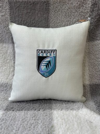 Cushion featuring a shield logo with a blue and black colour scheme.