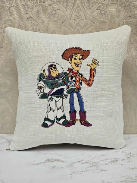 Cartoon characters Buzz Lightyear and Woody smiling and posing together on a cushion.