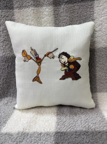 Embroidered cushion featuring a character and a bird in a playful pose.