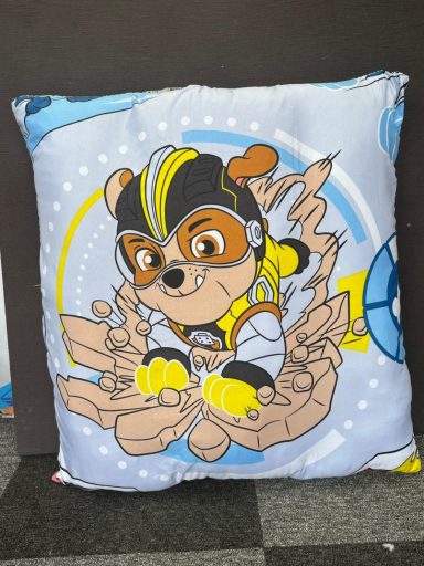 A decorative cushion featuring a cartoon dog in a pilot outfit, surrounded by clouds.